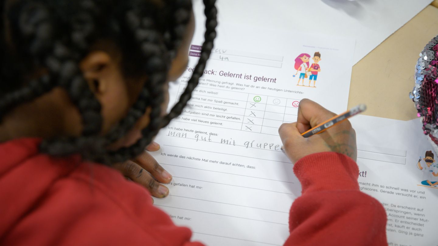 Finanzbildung für Kinder: Kind füllt einen Feedbackbogen zur finlit Initiative aus.