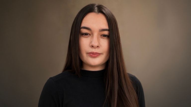 Daniela Moaca, Senior Manager IT bei EOS Romania, Porträtaufnahme in dunklem Rollkragenpullover.