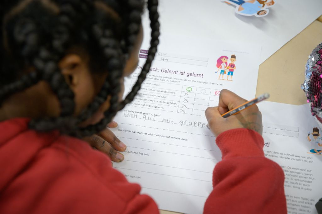 Finanzbildung für Kinder: Kind füllt einen Feedbackbogen zur finlit Initiative aus.